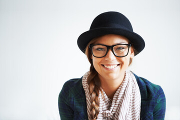Young, trendy and and confident. A young woman smiling at the camera against a white background.