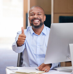 Thumbs up for a good work day. Shot of a young businessman showing a thumbs up in an office at work.