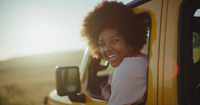 Beautiful young black african american woman smiling at sunset on summer road trip, travel and adventure lifestyle