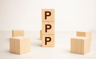 Three wooden cubes with letters PPP, stands for Praise Picture Push on white table