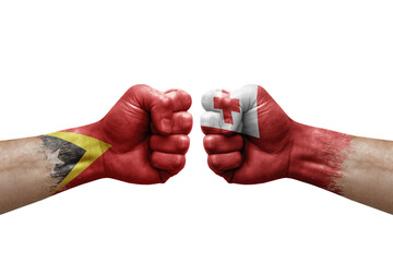 Fototapeta premium Two hands punch to each others on white background. Country flags painted fists, conflict crisis concept between timor leste and tonga