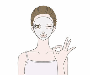フェイスパックをつけてOKマークをつくる女性
