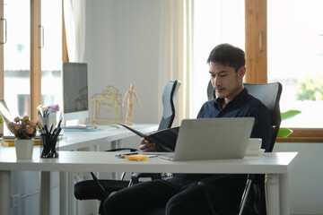 Fototapeta na wymiar Focused male entrepreneur working at comfortable workplace.