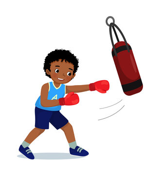 Cute little African boy boxer wearing boxing gloves hitting the punching bag training and exercising in the gym