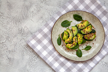 Toast with avocado, cottage cheese, spinach, sesame seeds, flax seeds. Healthy food rich in fiber, trace elements, omega acids, unsaturated lipids.