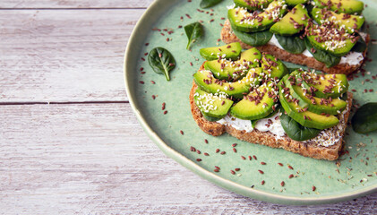 Toast with avocado, cottage cheese, spinach, sesame seeds, flax seeds. Healthy food rich in fiber, trace elements, omega acids, unsaturated lipids.