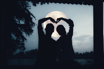 Silhouette romantic couple lover under the moon.