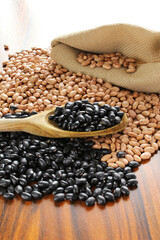 Black beans and carioca beans. Black beans spoon on carioca and black beans on the wooden table.