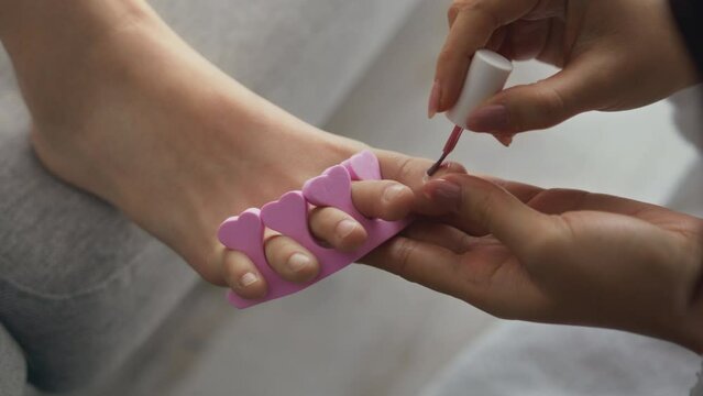 Beauty procedures at home. Close up shot of little girl foot, mother ,making pedicure for daughter, polishing toe nails