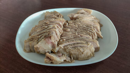 Photo of boiled pork that is cut into thin slices on white dish