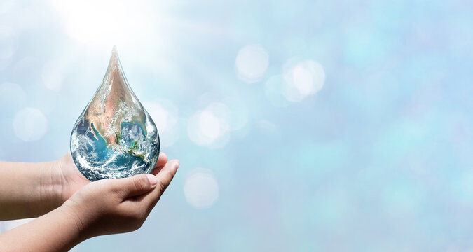 World water day. A globe in the shape of a drop of water falling onto the boy's hand on blue sea background. Elements of this image furnished by NASA
