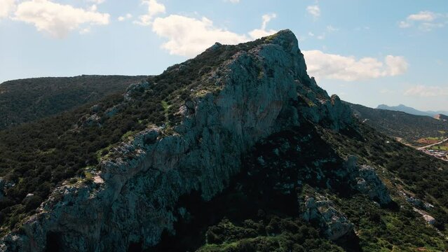Aerial 4k top view of Yudi Mountain surrounded with green nature and an amazing sea view in North Cyprus
