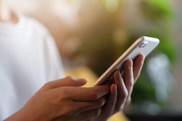 Hand holding smartphone and chatting with friends at social network on the table.