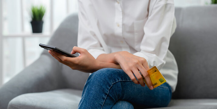 Close up of hand holding credit card with paying online on smartphone in internet store.