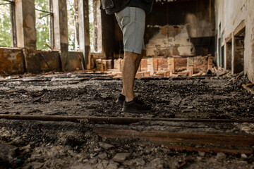 Destroyed building. Burnt building . Broken windows with ash . A man in a destroyed burnt building .