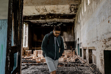 Destroyed building. Burnt building . Broken windows with ash . A man in a destroyed burnt building .