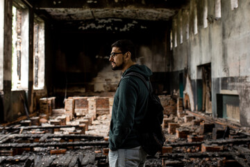 Destroyed building. Burnt building . Broken windows with ash . A man in a destroyed burnt building .