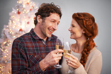 Spreading some Christmas cheers. Shot of an affectionate couple enjoying some champagne at Christmas.