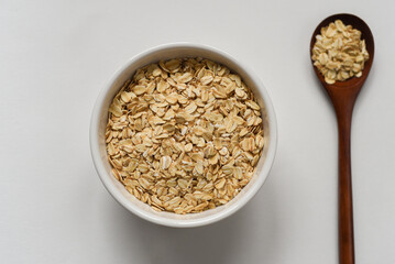 Raw oatmeal closeup in bawl on white background