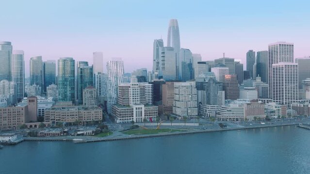 Aerial panorama of Embarcadero and Financial District skyscrapers and water front buildings, downtown San Francisco early morning on pink summer sky. 4K b roll drone shot sunrise scene, California USA
