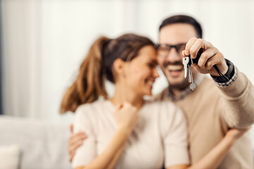 Close up of a man holding keys of new apartment for him and his wife.