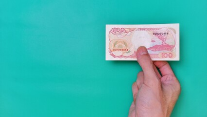 Indonesian Rupiah the official currency of Indonesia. Man's hand is making a payment. Male hand...