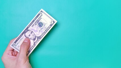 Man's hand is making a payment. Business Investment Economy Money Loan Saving Income and Finance concept. Male hand showing dollar bills on green background. Five Dollar. 5 USD. Prosperity concept.