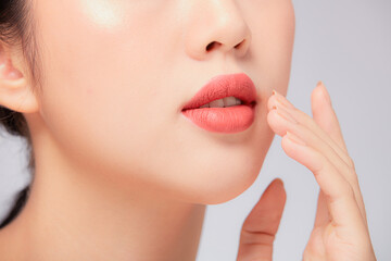 Obraz premium A close view of model showing lip posing with hand for cosmetic advertising