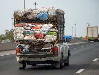 A pickup truck loaded with various materials ride on the highway