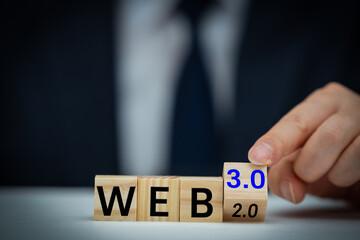 Businessman turns a wooden cube and changes words WEB 2.0 to WEB 3.0. Business, technology and WEB 3.0 concept.