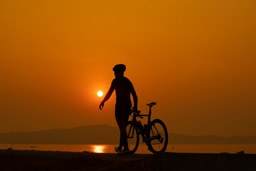 Fototapeta premium silhouette of a cyclist on sunset, the scenery sunrise in the morning in Thailand.