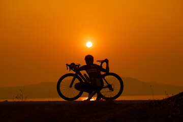 Obraz premium silhouette of a cyclist on sunset, the scenery sunrise in the morning in Thailand.
