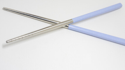 Stainless steel chopsticks with light purple plastic handle isolated on white background