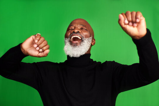 Im Living My Best Life. Cropped Shot Of A Senior Man Dancing Against A Green Background.