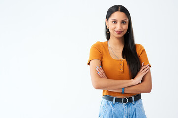 Confident beside copyspace. Cropped shot of an attractive young woman standing with her arms folded in studio against a grey background.