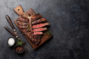 Grilled porterhouse beef steak. Sliced T-bone - obrazy, fototapety, plakaty