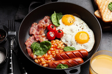 English breakfast with fried eggs, beans, bacon and sausages