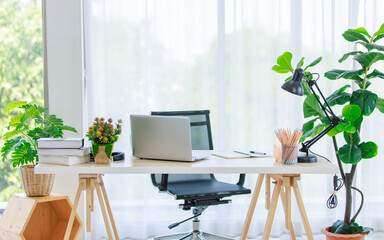 Interior architecture design workstation home office with wood table and adjustable chair with stationary equipment pencils laptop computer notebook textbooks lamp decor with tree basket flower pot