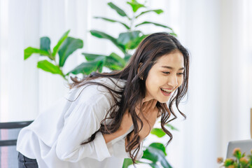 Asian young beautiful female university student sitting at working desk remotely studying learning streaming online via laptop notebook computer at home during quarantine