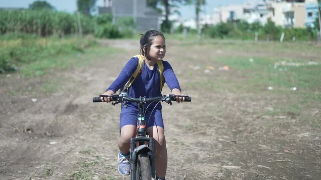 Indian kid cycling in a field. Kid going to school.Indin kid riding cycle in the morning going to school. Apple prores 422. High-quality 4k footage.