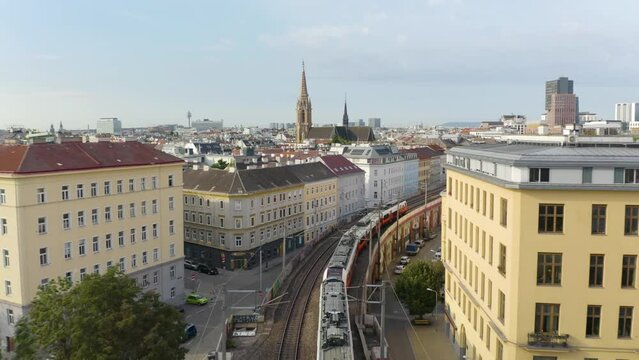 Vienna U-Bahn Train Travels Above City Street between Colorful Buildings on Beautiful Summer Day in Austria's Capital City