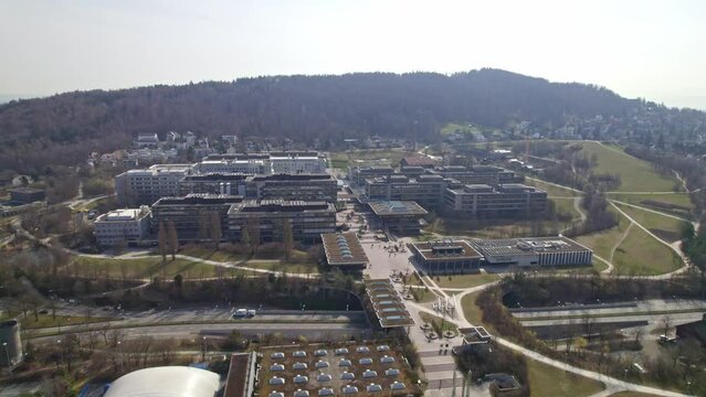 Aerial view of Z&uuml;rich University Campus Irchel witch park and pond on a sunny spring day. Movie shot March 21st, 2022, Zurich, Switzerland.