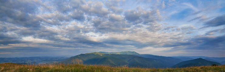 Obraz na płótnie Canvas Panorama of the evening sky. Beautiful clouds over the Carpathian mountains.