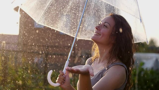 Happy young woman enjoying and having fun with umbrella outdoor at sunny weather. slow motion