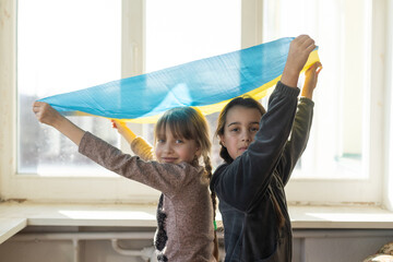 Two little child girls are sitting in shelter during bombings