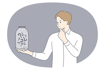 Asking doubt and frustration concept. Young man standing thinking and looking jar full of question marks inside feeling frustrated touching chin vector illustration 