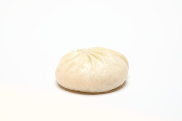 Delicious baozi, Chinese steamed meat bun is ready to eat on serving plate and steamer, close up, copy space product design concept.