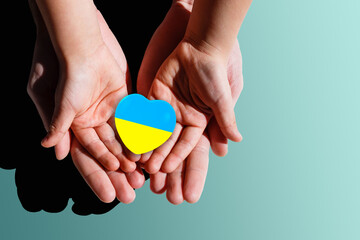 The national flag of ukraine with the coat of arms in female hands. Flat lay, copy space