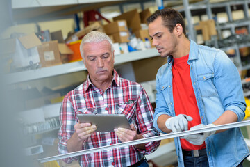 men looking at tablet in factory
