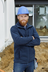 engineer with arm crossed wearing a helmet